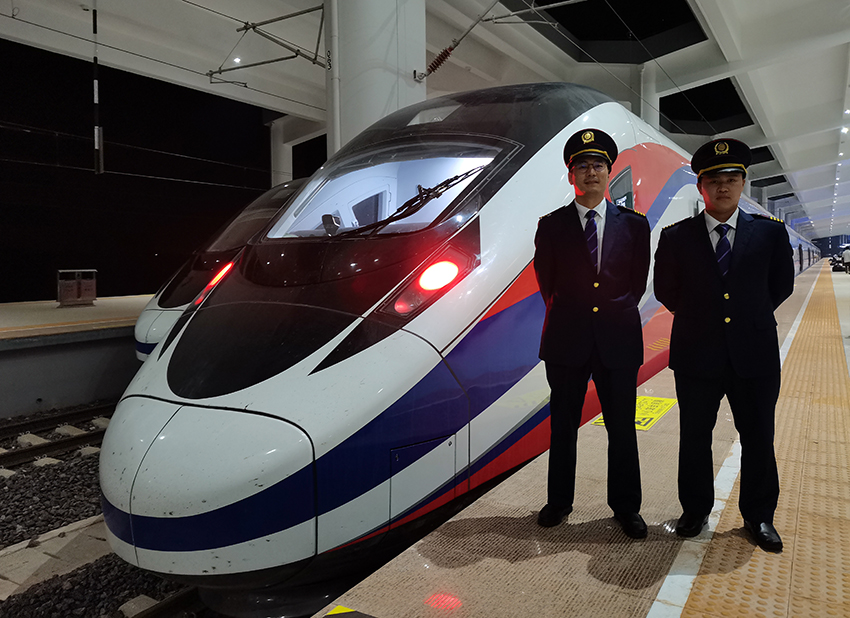 劉銀能（右一）與中國師父鄔俊鴻在動(dòng)車組前合影。受訪者供圖